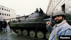 Сторонник Ичкерии осматривает танк российских войск в Грозном. 4 января 1995 года