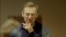 RUSSIA -- Russian opposition leader Aleksei Navalny, charged with defaming a World War II veteran, gestures from inside a glass cell during a court hearing in Moscow, February 16, 2021