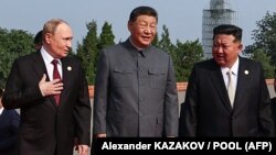 Президент России Владимир Путин беседует с лидером Китая Си Цзиньпином и лидером Северной Кореи Ким Чен Ыном после групповой фотографии перед военным парадом, 3 сентября 2025 года. Фото AFP