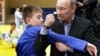 RUSSIA – Russia's Prime Minister Vladimir Putin (R) shows a hold to a young judo wrestler at the Regional Judo Center at the Arena Sports Complex in the Siberian city of Kemerovo, 24 January 2012