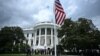 TOPSHOT - US President Donald Trump looks on as a US flag is raised on a newly installed flagpole on the South Lawn of the White House in Washington, DC on June 18, 2025.