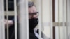  BELARUS -- Viktar Babaryka, former head of Belgazprombank and challenger in the 2020 presidential election, who was jailed on corruption charges, sits inside a defendants' cage before a court hearing in Minsk, February 17, 2021