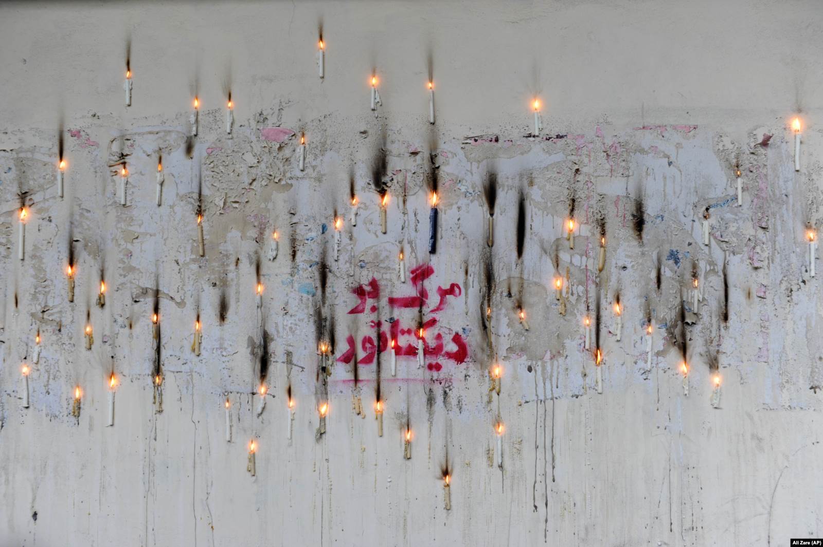 Импровизированный мемориал погибшим во время расстрела демонстрантов. На стене написано "Смерть диктатору". 16 июня 2009