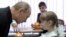 Vladimir Putin talks with a pupil during a visit to a schoo