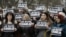 Spain -- Spanish journalists hold posters reading 'Je suis Charlie' (I am Charlie) to show their solidarity with the victims of the massacre at the headquarters of French satirical magazine Charlie Hebdo in Paris during a minute of silence in Pamplona, no