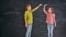 Generic -- Two children sisters play together. Kid measures the growth on the background of blackboard. Concept of education.