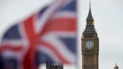 A Union flag flies in the wind in front of the Big Ben clock face and the Elizabeth Tower at the Houses of Parliament in central London
