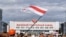 BELARUS – Protest in Belarus nearby Minsk tractor plant, flag of protesters over the factory and workers coming from their shifts, the beginning of a strike. Minsk, August 18, 2020
