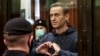 RUSSIA -- Russian opposition leader Aleksei Navalny shows a heard symbol standing in the cage during a court hearing in Moscow, February 2, 2021