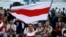 Minsk, Belarus - A person waves a historical white-red-white flag of Belarus as people take part in a rally to protest against presidential election results, at the Independence Square